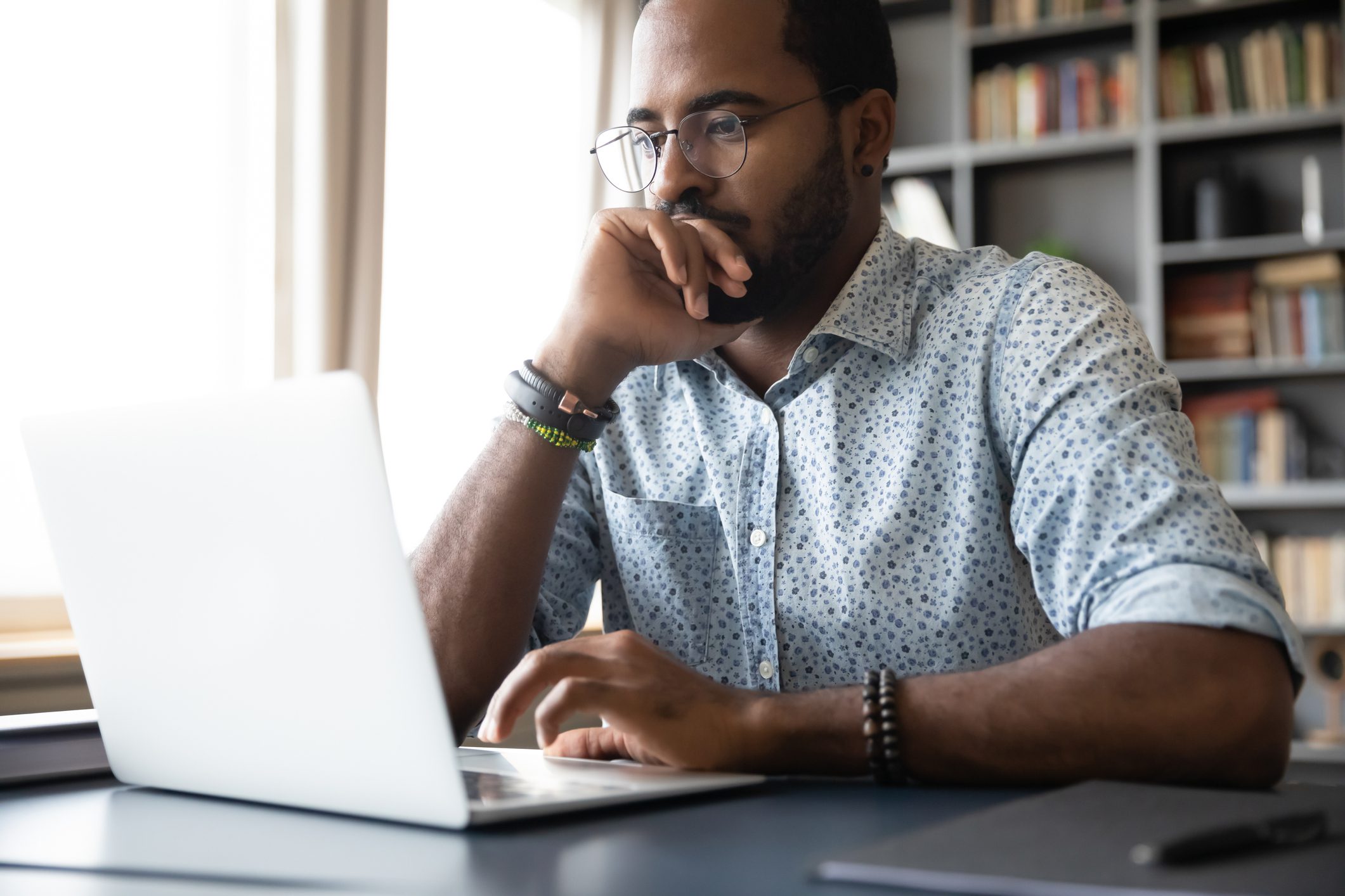 Male African American Business owner looking at his laptop with focus