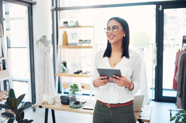 Female business owner smiling while holding a tablet