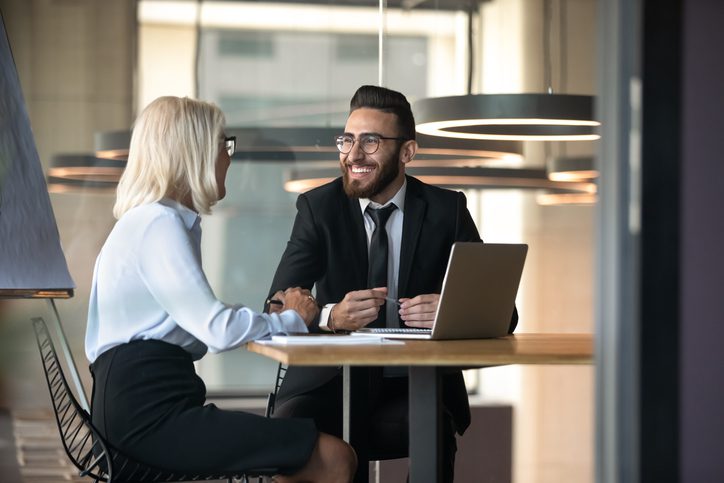 Mature female business owner sits at desk discussing accounting with a CPA