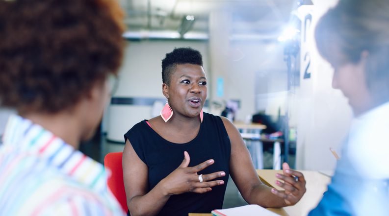 African American Female executive offering feedback to her team.