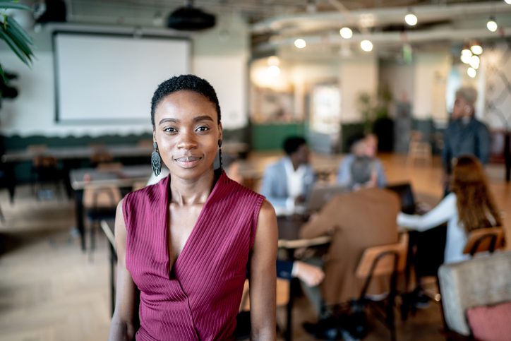 African American female business owner presenting to a large organization with confidence