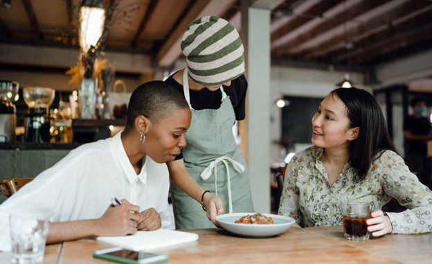 two customers being served food at a local small food service business