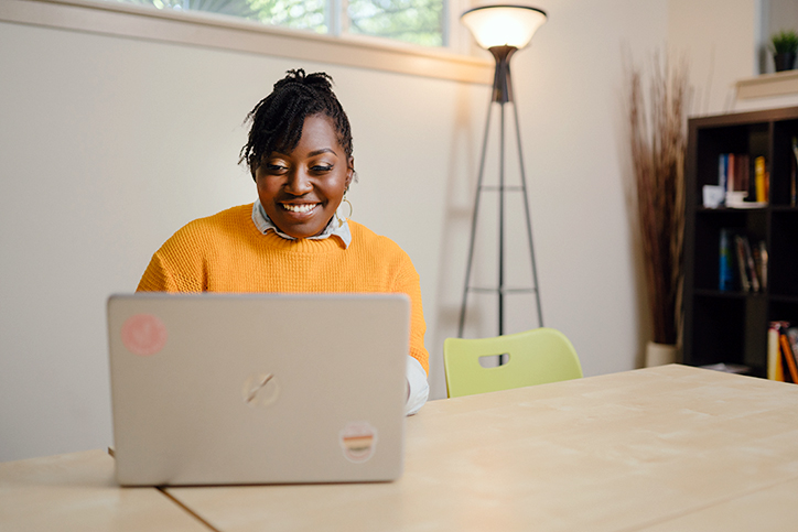 Lendistry customer Jaree Cottman of AFYA Counseling & Wellness Services smiling while looking at her laptop