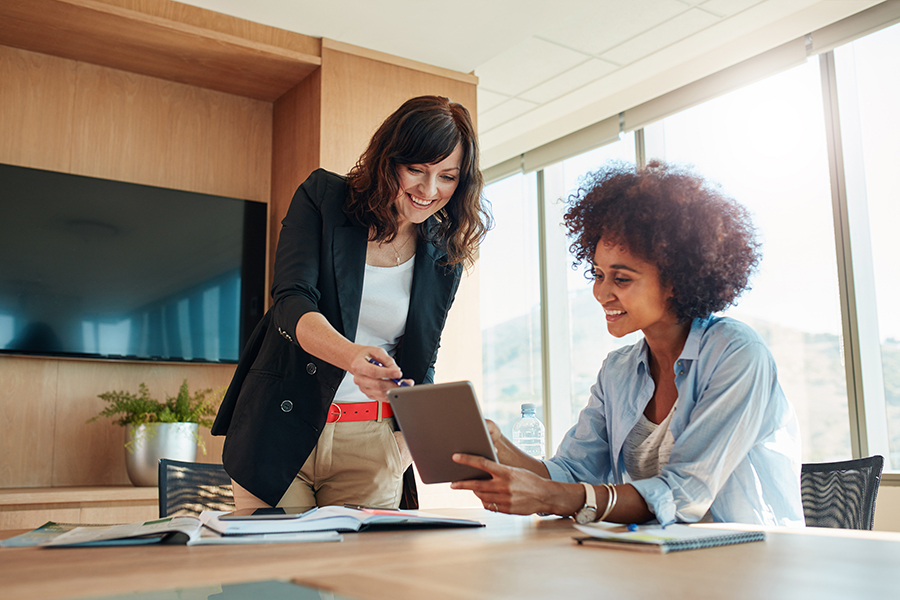 2 female professionals looking at a document in a office setting