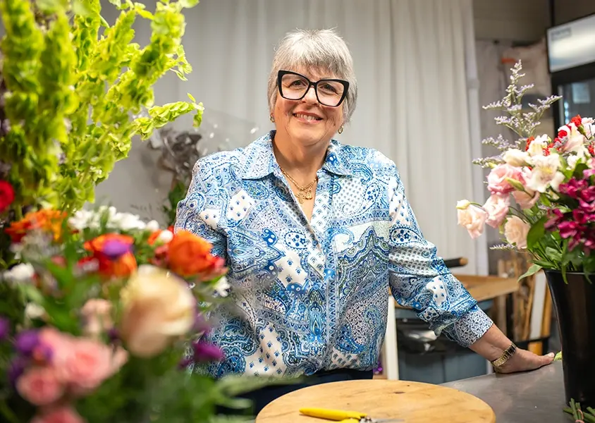 Maria De Portillo, Acuarela Florist, Land O' Lakes, FL smiling for camera at her florist shop